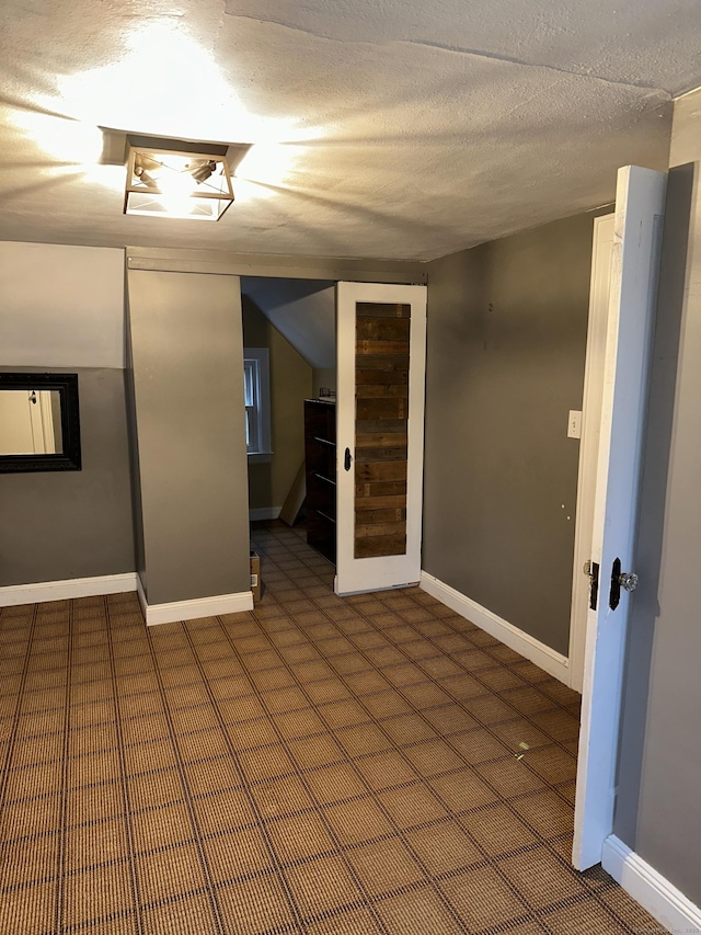 unfurnished room with a textured ceiling