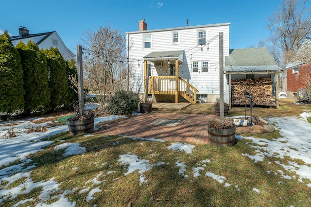 snow covered property featuring roof with shingles and a chimney