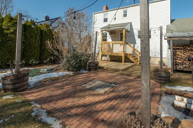 rear view of property featuring a patio and a chimney