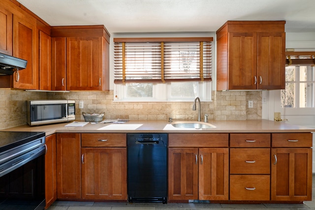 kitchen featuring decorative backsplash, brown cabinets, stainless steel appliances, light countertops, and a sink