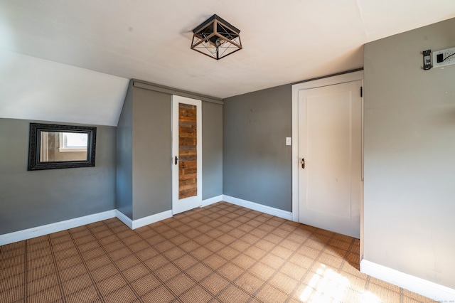 additional living space featuring light floors and baseboards