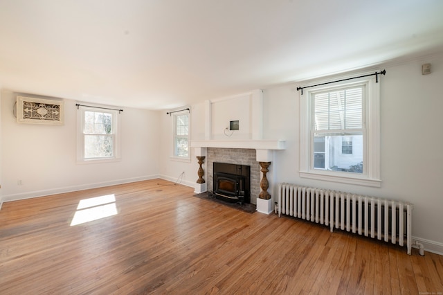 living room with light wood-style floors, baseboards, and radiator heating unit