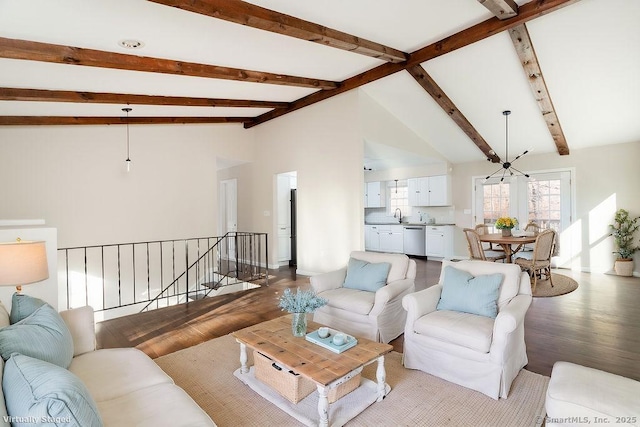 living room with high vaulted ceiling, an inviting chandelier, sink, light wood-type flooring, and beam ceiling