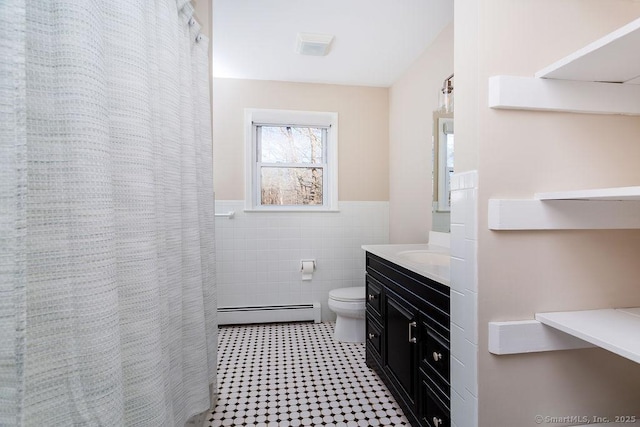 bathroom featuring a baseboard radiator, a shower with curtain, toilet, vanity, and tile walls