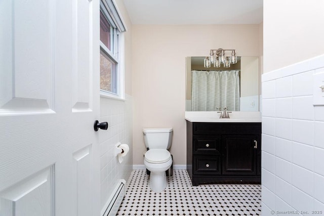 bathroom with vanity, toilet, tile walls, and a baseboard heating unit