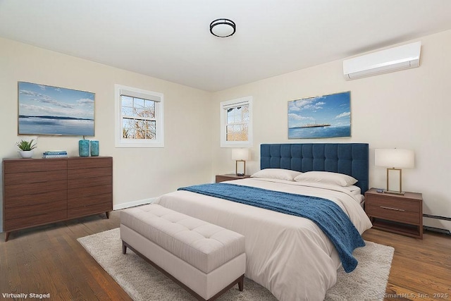 bedroom featuring baseboard heating, dark hardwood / wood-style floors, and a wall mounted air conditioner