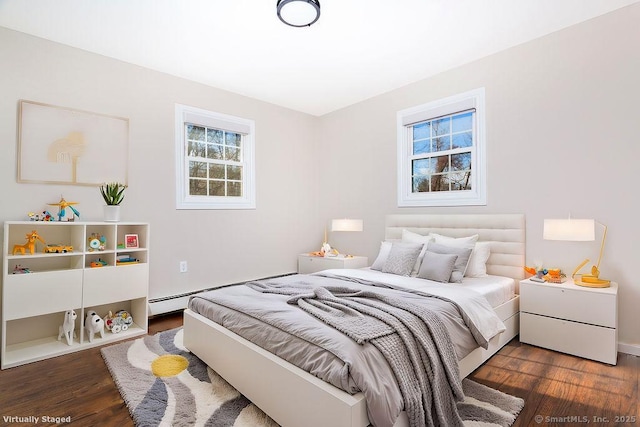 bedroom featuring dark hardwood / wood-style flooring and a baseboard heating unit