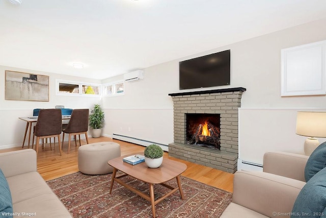 living room featuring a brick fireplace, wood-type flooring, an AC wall unit, and a baseboard radiator