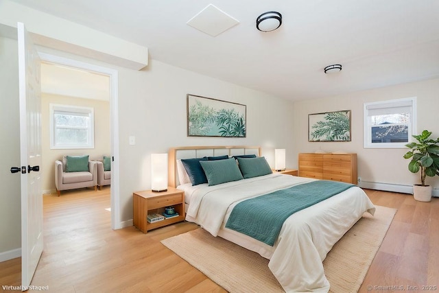 bedroom with light hardwood / wood-style flooring and a baseboard radiator