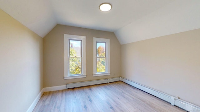 bonus room with light hardwood / wood-style flooring, vaulted ceiling, and a baseboard heating unit