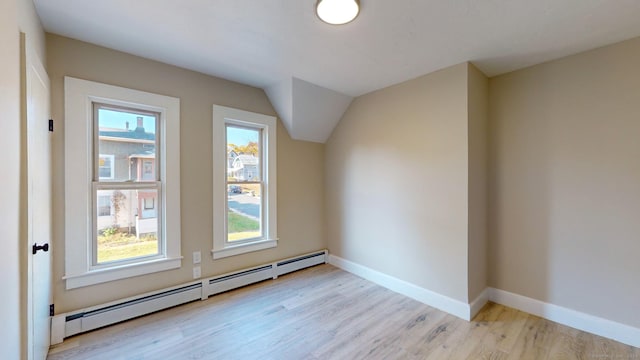 bonus room with light wood-type flooring and a baseboard heating unit