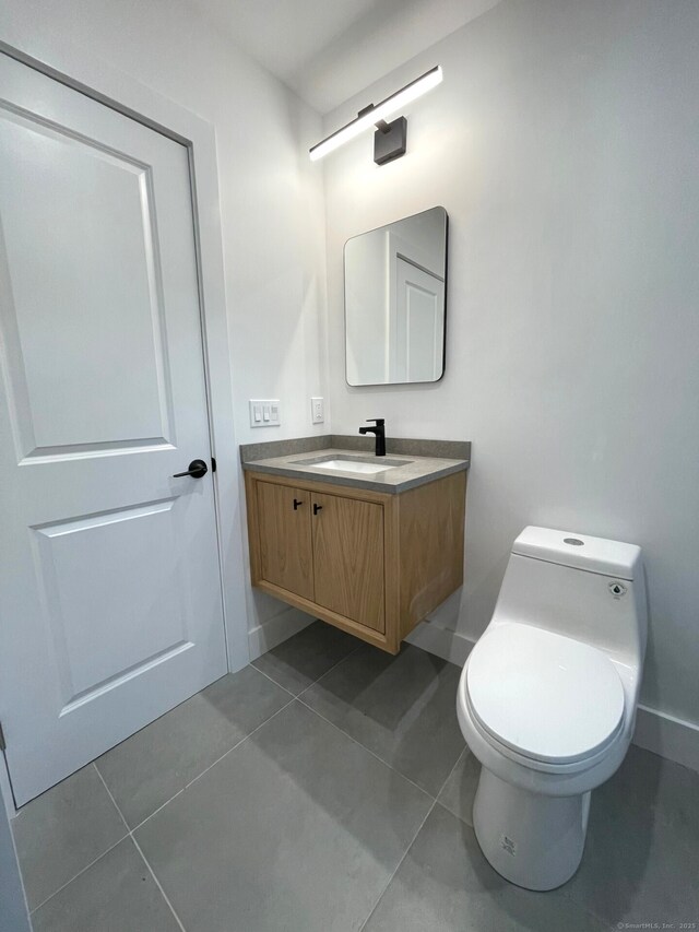 bathroom featuring tile patterned flooring, vanity, and toilet