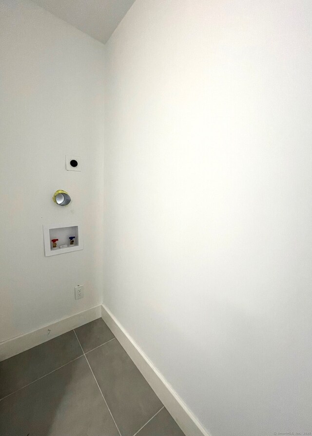 washroom with washer hookup, dark tile patterned flooring, and hookup for an electric dryer