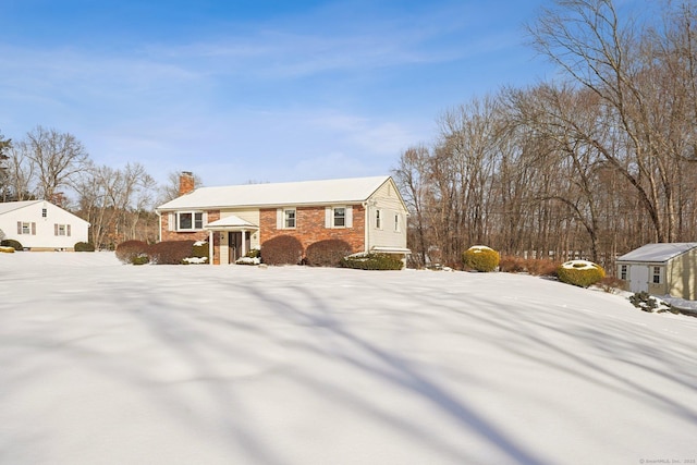 raised ranch with a chimney and brick siding