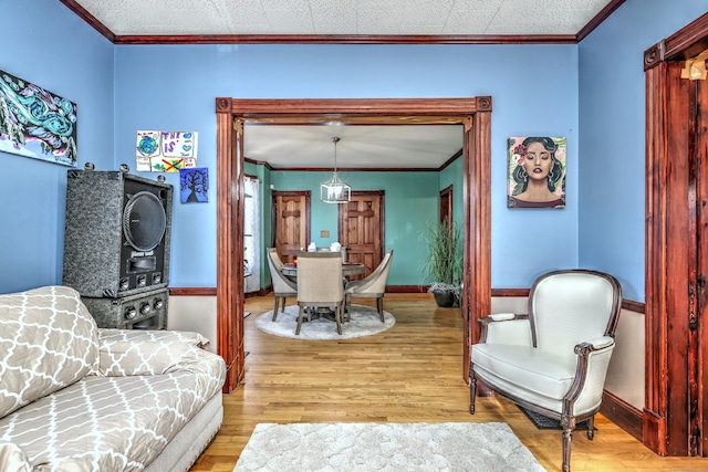 sitting room with light hardwood / wood-style floors and crown molding