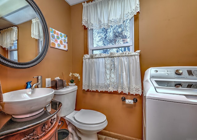 bathroom featuring washer / clothes dryer, toilet, and sink