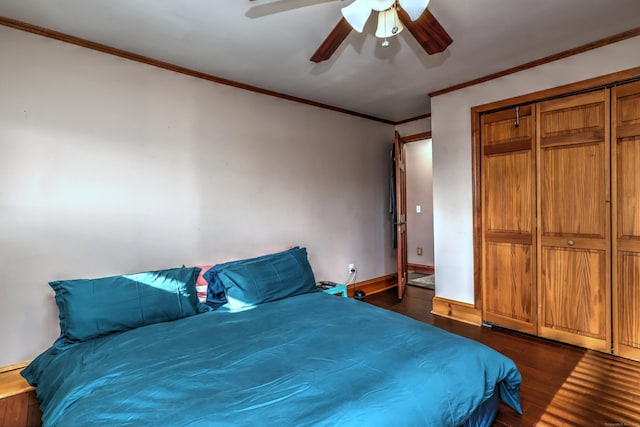 bedroom with ceiling fan, dark hardwood / wood-style floors, crown molding, and a closet