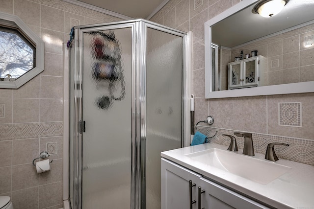 bathroom with vanity, an enclosed shower, and tile walls