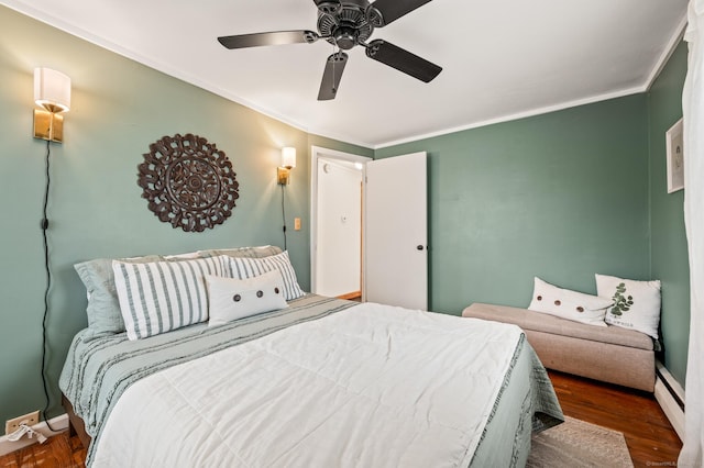 bedroom featuring baseboard heating, ceiling fan, crown molding, and dark hardwood / wood-style floors