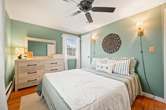 bedroom featuring ceiling fan, wood-type flooring, ornamental molding, and a baseboard radiator