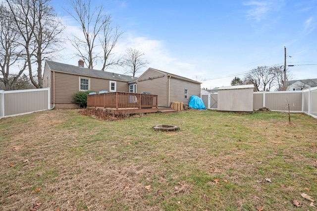 view of yard featuring an outdoor fire pit, a storage unit, and a deck