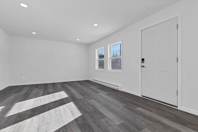 foyer entrance with dark wood-type flooring and a baseboard heating unit