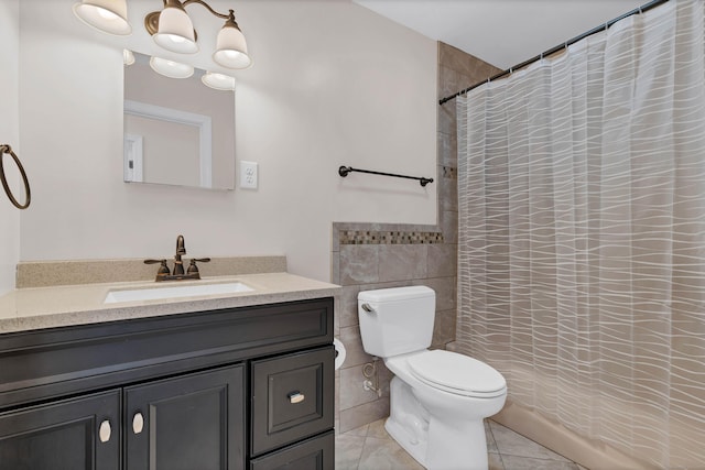 bathroom with a shower with curtain, tile patterned flooring, toilet, vanity, and tile walls