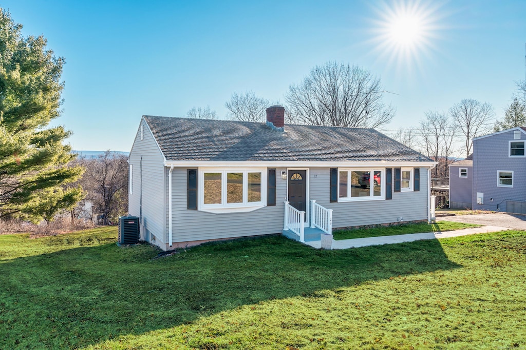 ranch-style home featuring a front yard and central AC