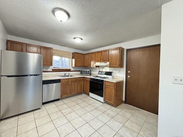 kitchen featuring sink, stainless steel appliances, and a textured ceiling