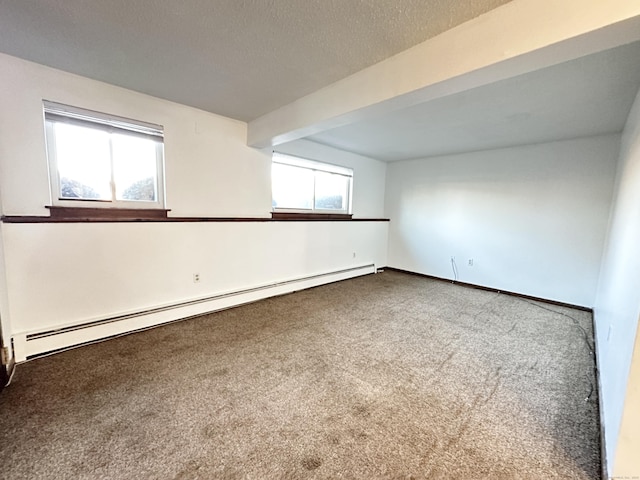 spare room featuring beamed ceiling, carpet, a textured ceiling, and a baseboard heating unit