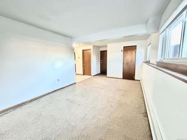 empty room with light carpet and a baseboard radiator