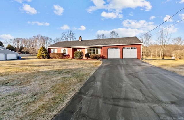 ranch-style home featuring a garage and a front yard