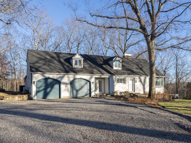 cape cod-style house featuring a garage