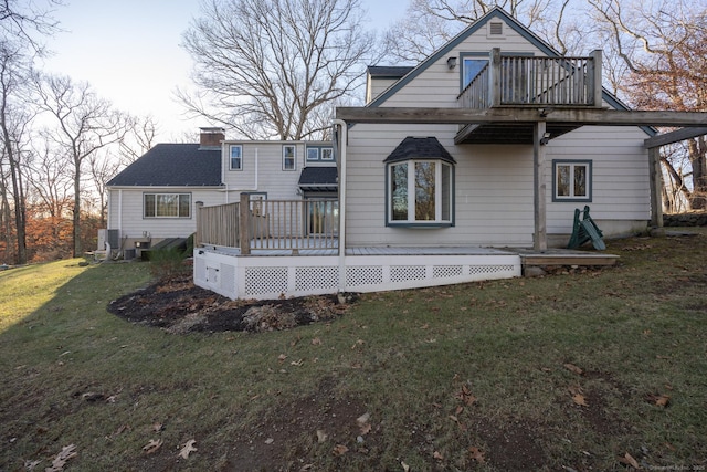 rear view of property with a yard and a deck