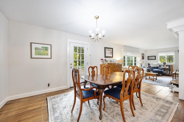 dining area with hardwood / wood-style floors and an inviting chandelier