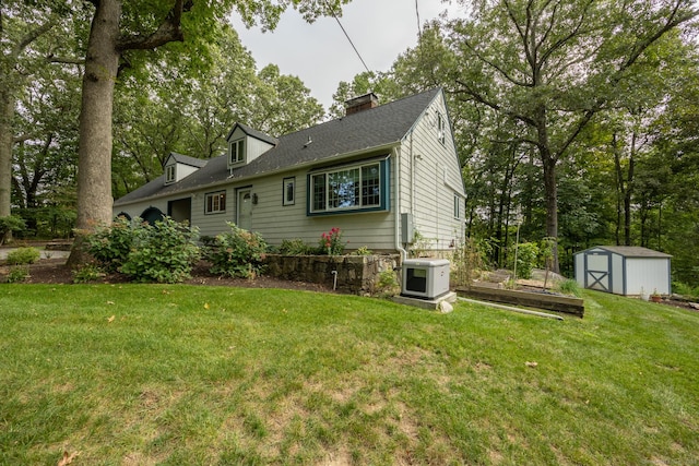 rear view of house featuring a shed and a lawn