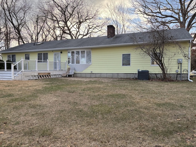 rear view of house with central AC, a yard, and a wooden deck