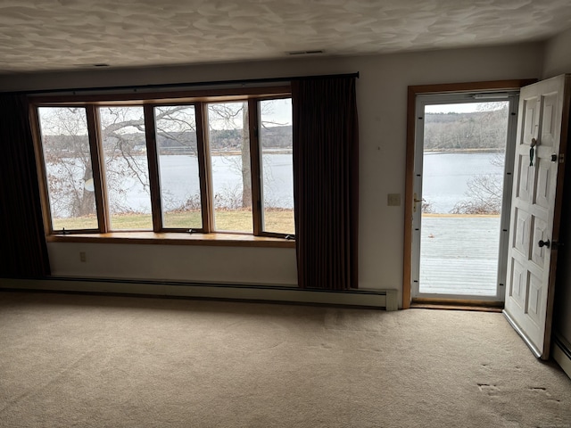 carpeted empty room featuring a water view and a healthy amount of sunlight