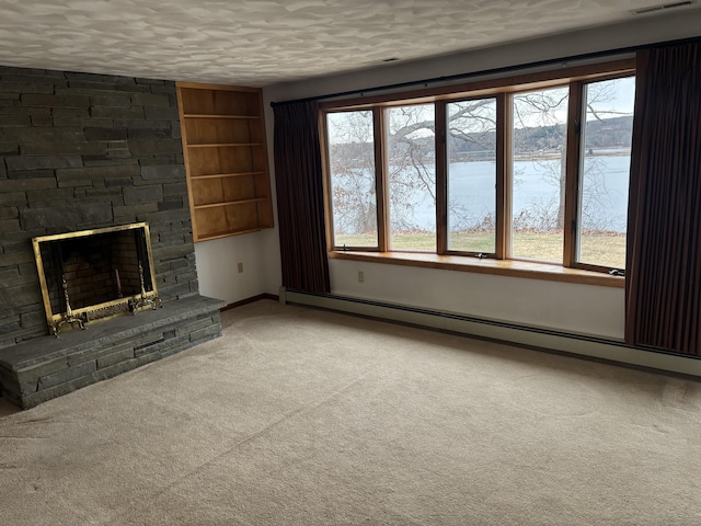 unfurnished living room with carpet, a stone fireplace, a water view, a textured ceiling, and a baseboard radiator