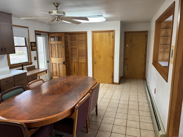 tiled dining room featuring ceiling fan and baseboard heating