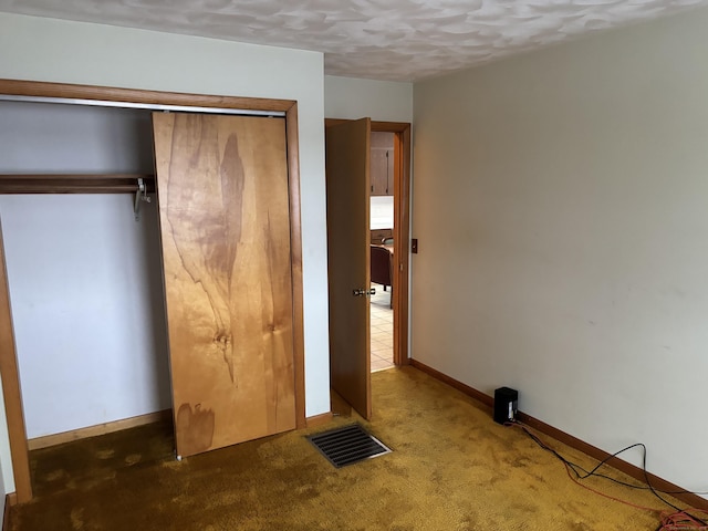 unfurnished bedroom with a closet and dark colored carpet