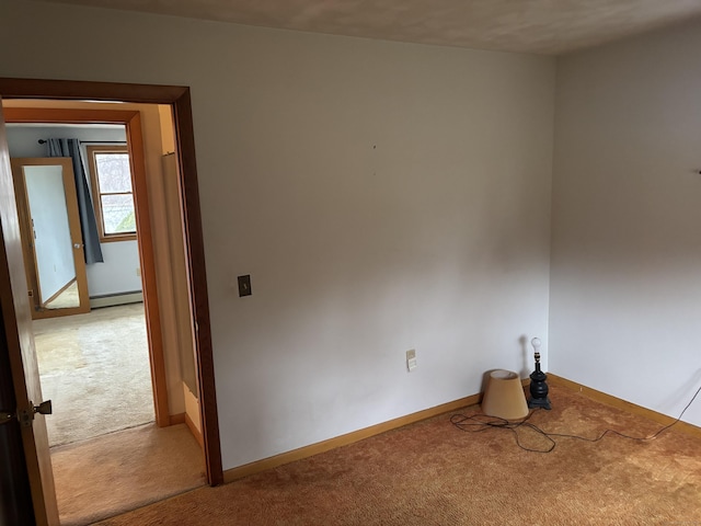 carpeted empty room with a baseboard radiator