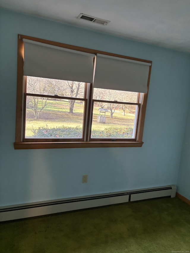 carpeted empty room featuring baseboard heating