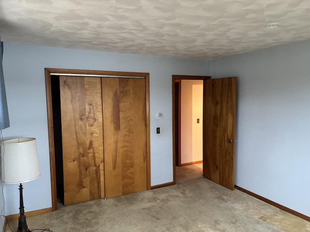 unfurnished bedroom featuring light carpet and a closet