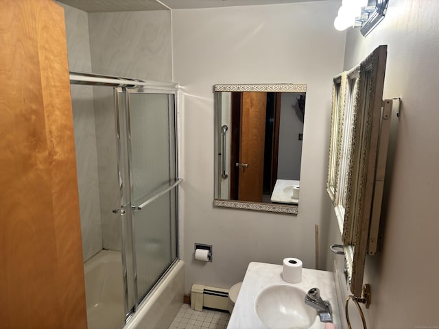 bathroom featuring combined bath / shower with glass door, tile patterned flooring, a baseboard heating unit, and sink