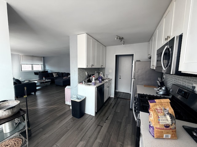 kitchen featuring white cabinetry, sink, stainless steel appliances, dark hardwood / wood-style floors, and decorative backsplash