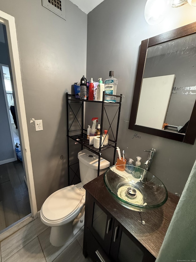 bathroom with tile patterned flooring, vanity, and toilet