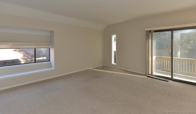 unfurnished room with carpet floors and vaulted ceiling