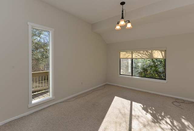 carpeted empty room featuring a chandelier and lofted ceiling