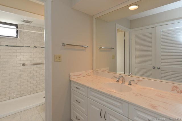 bathroom featuring vanity and tiled shower